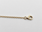 A close-up of a yellow gold bracelet chain with a lobster clasp on a light gray background, showing 10k hallmark