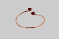 Ophelisse Solid 10k Rose gold bracelet bangle with heart-shaped natural  red garnet gemstones, on a gray background
