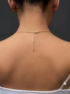 A close-up back view of a real model wearing Ophelisse gold chain necklace, resizable to 16, 18, and 20-inch