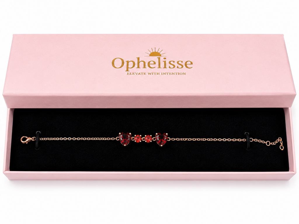 A solid 10k rose gold chain bracelet with two red heart-shaped and two round-shaped natural garnet gemstones, presented in an open light pink Ophelisse gift box with a black velvet interior.