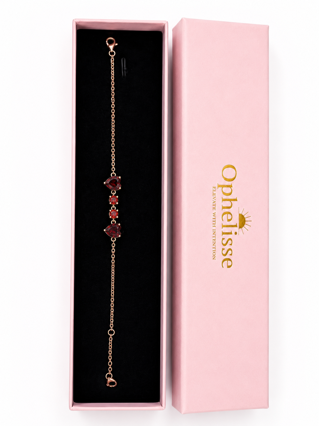 A solid 10k rose gold chain bracelet with four natural red garnet gemstone accents, presented in Ophelisse luxurious packaging - an open pink jewelry box next to its pink lid box in portrait view.