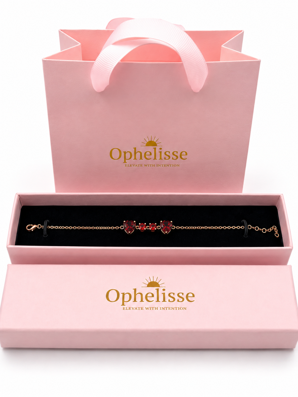 A solid 10k rose gold chain bracelet with natural red garnet heart charms is displayed in an open Ophelisse pink jewelry box, with a matching pink branded gift bag behind it on a white background.