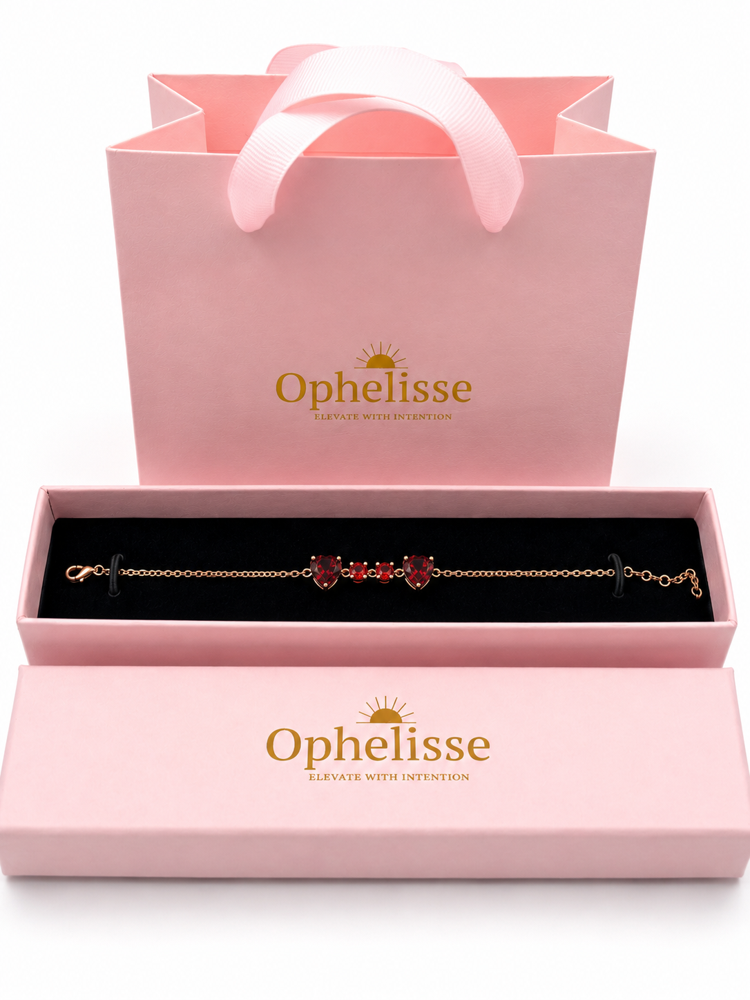 A solid 10k rose gold chain bracelet with natural red garnet heart charms is displayed in an open Ophelisse pink jewelry box, with a matching pink branded gift bag behind it on a white background.