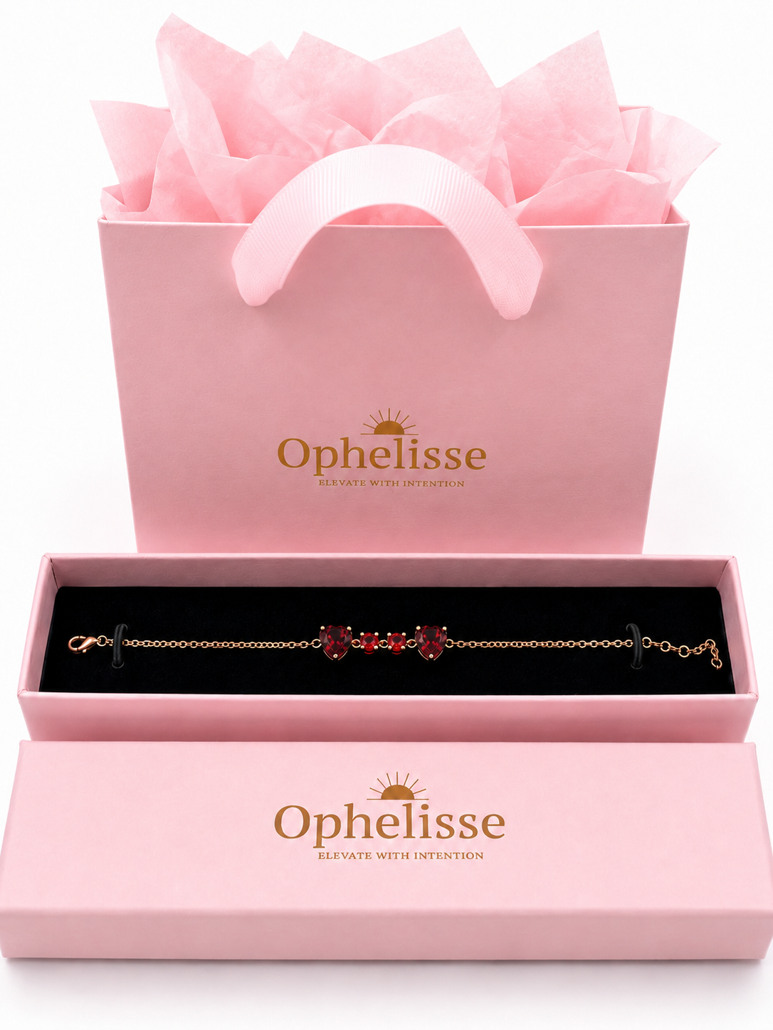A solid 10k rose gold chain bracelet with natural red garnet gemstones displayed in an open pink Ophelisse presentation box, with a matching pink gift bag filled with tissue paper behind it on a white background.