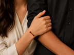 Close-up lifestyle photo of Ophelisse solid 10k rose gold on wrist, featured two heart-shaped and two small round-shaped natural red garnet gemstones, people holding hands, with a focus on a bracelet on one wrist.