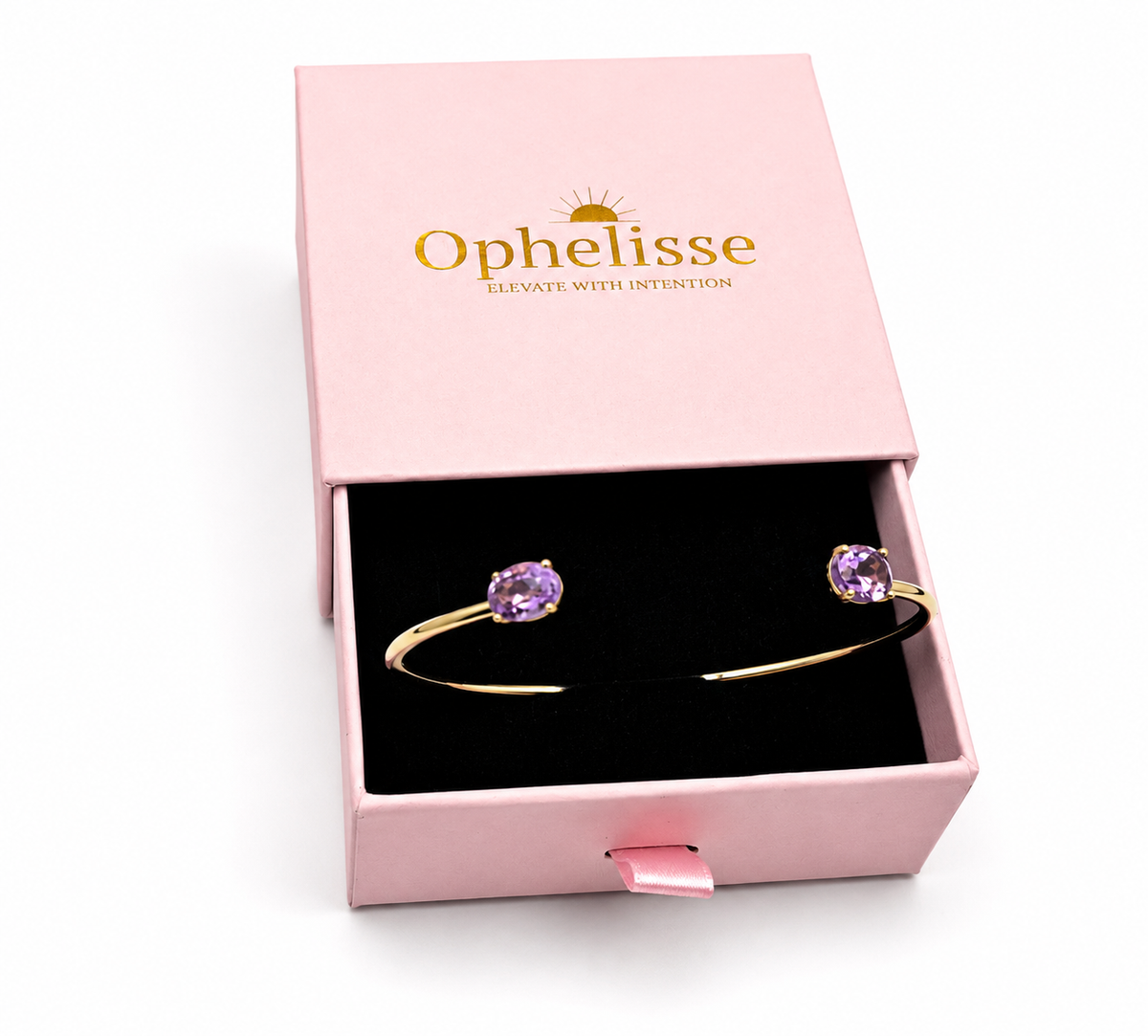 A solid 10k yellow gold bangle with natural oval purple amethyst gemstones, presented in an open pink Ophelisse jewelry box with a black velvet insert.