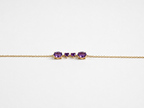 Ophelisse solid 10k yellow gold chain bracelet featuring two oval and two heart natural purple amethyst gemstones, shown closed up and side angle view against white background.