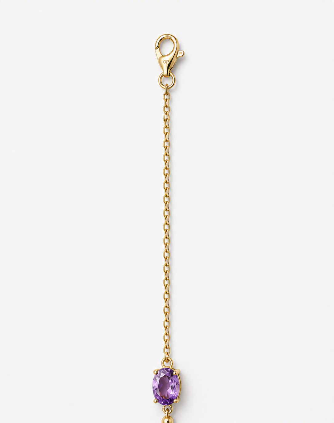 A part of a solid 10k yellow gold chain with a lobster clasp and an oval natural purple amethyst gemstone showing Ophelisse trademark, shown on a light gray background.